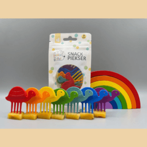 Zu sehen ist das Snack Piekser Set "Schildkröten" von Pieksi und Griffel, aus sieben Schildkröten in den Farben des Regenbogens, zu sehen vor einem hölzernen Regenbogen und der Verpackung.