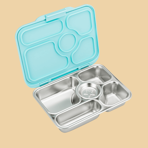 Zu sehen ist die Vesperdose "Yumbox Presto" aus Edelstahl mit fünf Fächern und einem hellblauen Deckel aus Silikon, die geöffnete Dose schräg von der Seite fotografiert.