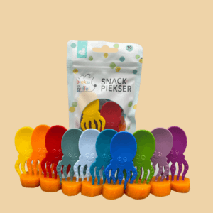 Zu sehen ist das "Pacific's Ten" Set der Snack Piekser Tintenfische von Pieksi und Griffel in vielen bunten Farben. Alle zehn stecken in einzelnen kleinen Karottenstücken und im Hintergrund ist die Verpackung zu sehen.
