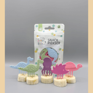 Zu sehen ist das Snack Piekser Set "Pastell" von Pieksi und Griffel, bestehend aus fünf Pieksern (zwei Dinosaurier, ein Tintenfisch, ein Igel und eine Schildkröte), zu sehen vor der Verpackung.